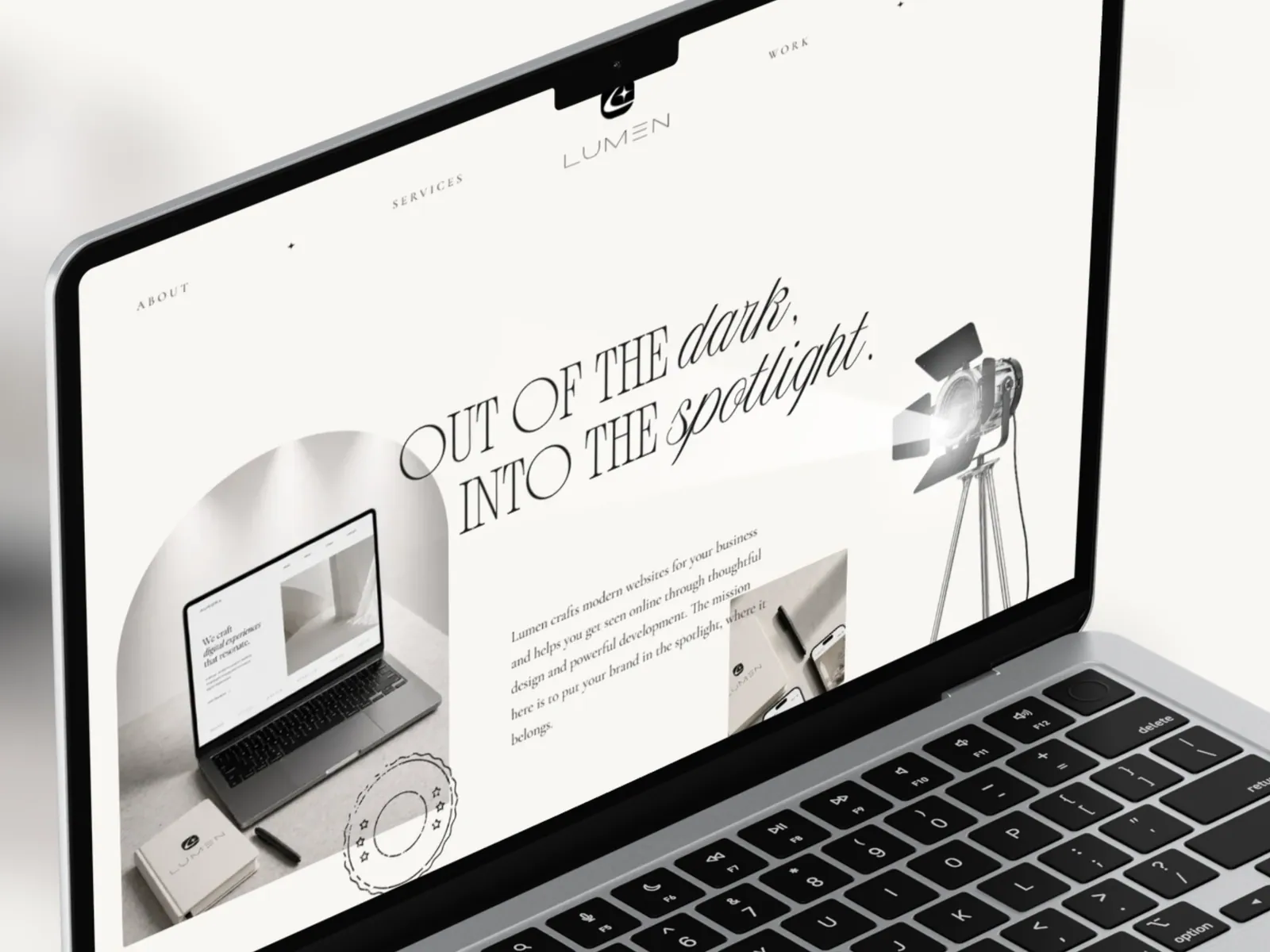 The Lumen homepage hero on a laptop, with a studio spotlight casting a beam